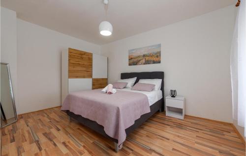 1 dormitorio con 1 cama grande con almohadas rosas en 3 Bedroom Lovely Home In Bruska, en Donja Bruška