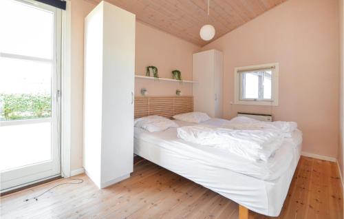 エーベルトフトにあるAmazing Home In Ebeltoft With 3 Bedrooms And Wifiのベッドルーム(白いベッド1台、大きな窓付)