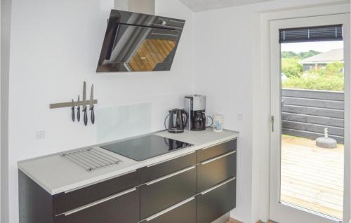 eine Küche mit einer Spüle und einem Herd in der Unterkunft 4 Bedroom Awesome Home In Hadsund in Haslevgårde