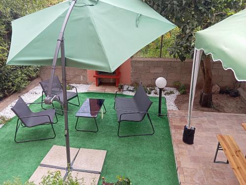 a group of chairs and an umbrella on a lawn at Casa Clara Oristano centro con giardino in Oristano