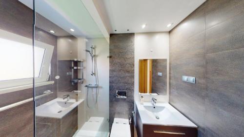 a bathroom with two sinks and two mirrors at Zion guest house in Almada