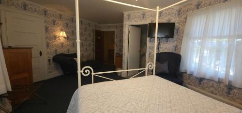 a bedroom with a canopy bed and blue wallpaper at Old Orchard Beach Inn in Old Orchard Beach