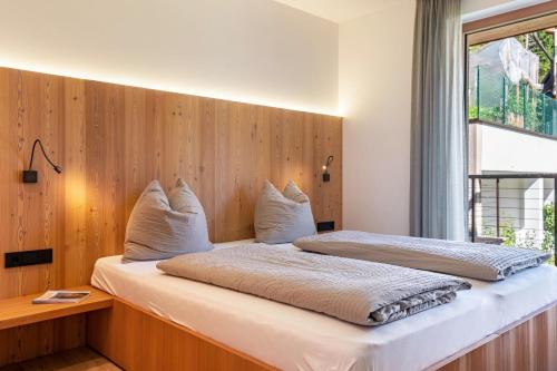 サンタ・クリスティーナ・ヴァルガルデーナにあるVista Dolomites Apartment Harmonyのベッド2台と窓のある寝室