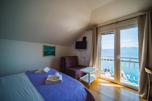 a bedroom with a bed and a view of the ocean at Apartments and Rooms Denoble in Korčula