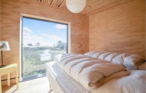 エーベルトフトにあるPet Friendly Home In Ebeltoft With Saunaの木製の壁と大きな窓が備わる客室です。