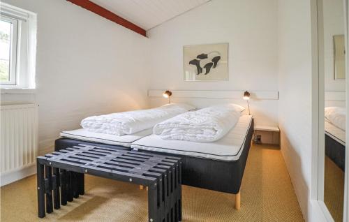 エーベルトフトにあるAmazing Home In Ebeltoft With 3 Bedrooms And Wifiのベッドとベンチ付きの小さな部屋です。