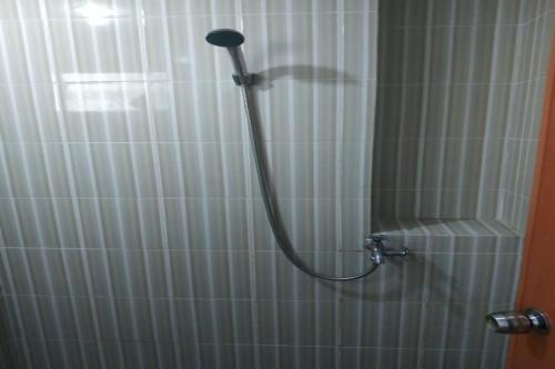 eine Dusche mit einem Schlauch im Bad in der Unterkunft OYO Life 92745 The Margo Monthly Stay in Depok