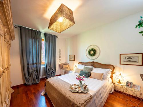 Un dormitorio con una cama con una bandeja de flores. en Olearum apartment (free Parking), en Pieve di Panzano