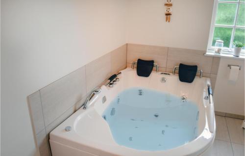 een bad in de badkamer met bij 5 Bedroom Awesome Home In Hadsund in Nørre Hurup