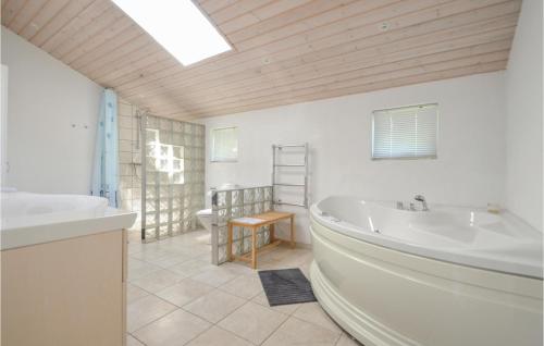 エーベルトフトにあるStunning Home In Ebeltoft With Saunaのバスルーム(バスタブ、洗面台、トイレ付)