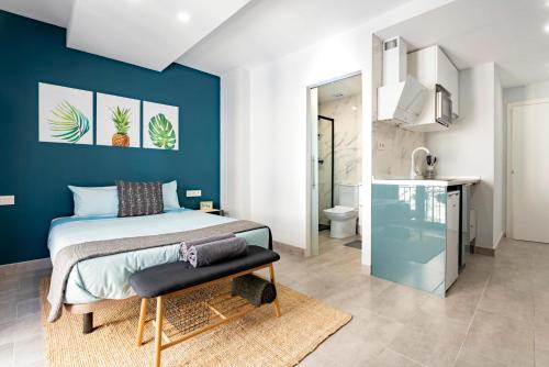 ein Schlafzimmer mit einem Bett und einer blauen Wand in der Unterkunft Oleti Studio Granada in Granada
