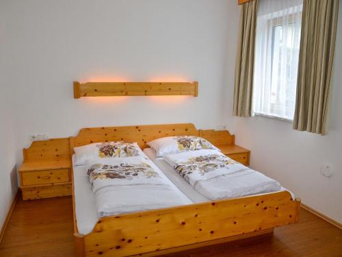 a wooden bed with two pillows on it in a room at Apartment Schöngraben by Interhome in Sankt Jakob