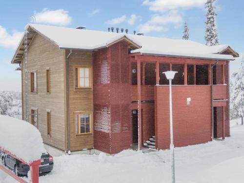 una casa di legno nella neve con una macchina davanti di Holiday Home Länsirinne e 19 by Interhome a Ruka