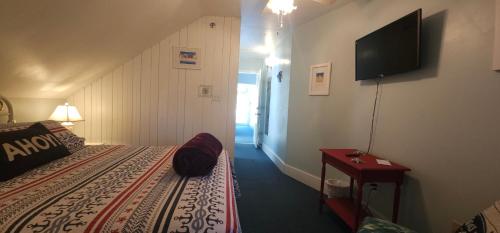 a room with a bed and a television on a wall at Old Orchard Beach Inn in Old Orchard Beach