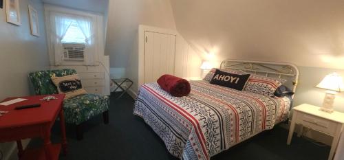 a small bedroom with a bed and a chair at Old Orchard Beach Inn in Old Orchard Beach