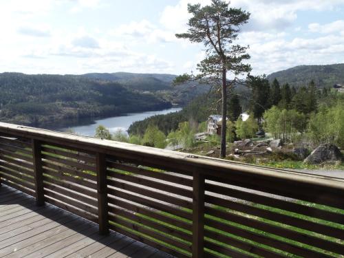 una terraza de madera con vistas al río. en Chalet Fjellkos - SOW146 by Interhome en Fossdal