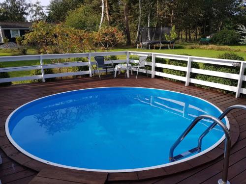 a large blue pool on a deck with a fence at Holiday Home Asmine - 670m from the sea in Lolland- Falster and Mon by Interhome in Dannemare