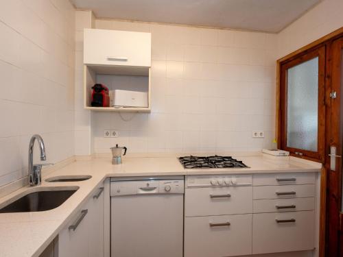 - une cuisine blanche avec évier et cuisinière dans l'établissement Apartment Zodiak by Interhome, à Pineda de Mar