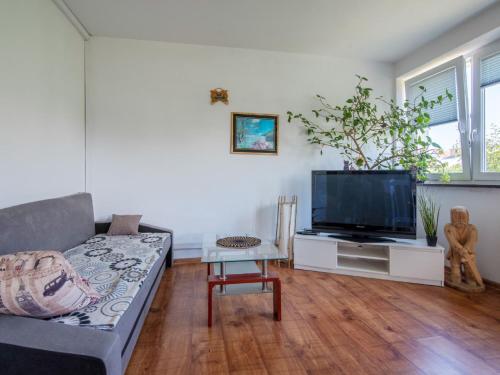 a living room with a couch and a flat screen tv at Holiday Home Parkowa by Interhome in Koszalin