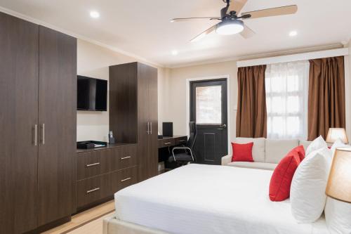 - une chambre avec un lit, un canapé et une télévision dans l'établissement Myah's Hotel, à Brighton Village
