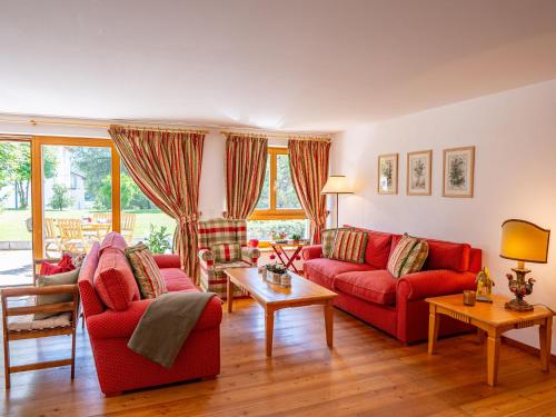 a living room with two red couches and a table at Apartment Chesa Dal Luf B1 by Interhome in Silvaplana