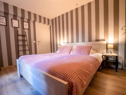 um quarto com uma cama com uma parede listrada em Apartment Amuzee with parking by Interhome em Blankenberge