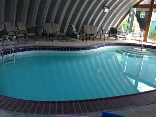 a swimming pool in a tent with chairs around it at Old Field House in North Conway