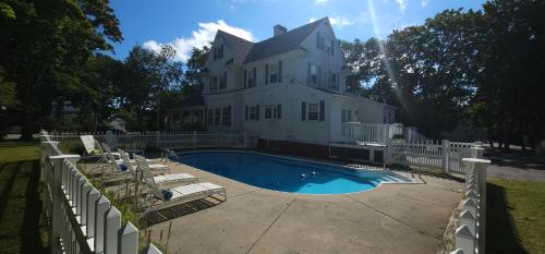 a white house with a swimming pool in front of it at Old Orchard Beach Inn in Old Orchard Beach