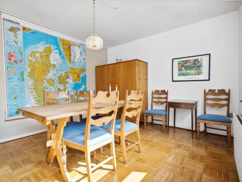 a dining room with a table and chairs and a map at Holiday Home Magh - 9-8km from the sea in Western Jutland by Interhome in Tønder