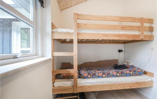 Etagenbett in einem kleinen Zimmer mit Fenster in der Unterkunft 3 Bedroom Lovely Home In Ebeltoft in Ebeltoft