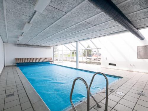 a large indoor swimming pool with blue water at Apartment Virpi - 1km from the sea in NW Jutland by Interhome in Blokhus