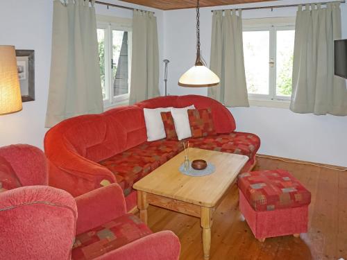 a living room with a red couch and a table at Chalet Lieblingsplatz by Interhome in Flirsch