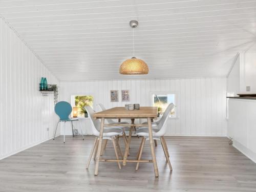 ein Esszimmer mit einem Holztisch und Stühlen in der Unterkunft Holiday Home Blaguna - 600m from the sea in NW Jutland by Interhome in Torsted