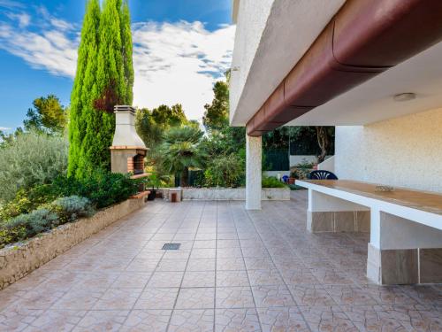 une terrasse d'une maison avec un banc et des arbres dans l'établissement Villa El Refugio-2 by Interhome, à Oropesa del Mar