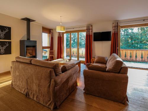 a living room with two couches and a fireplace at Chalet Dipankar by Interhome in Villars-sur-Ollon