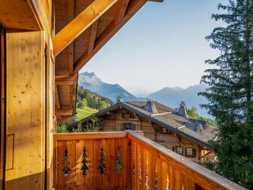 a log cabin balcony with a view of the mountains at Chalet Dipankar by Interhome in Villars-sur-Ollon