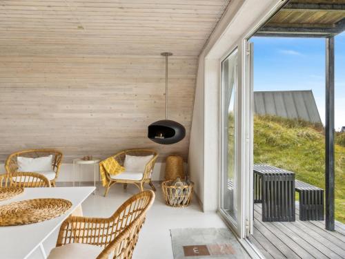 een kamer met een balkon met een tafel en stoelen bij Holiday Home Pauli - 350m from the sea in NW Jutland by Interhome in Pandrup
