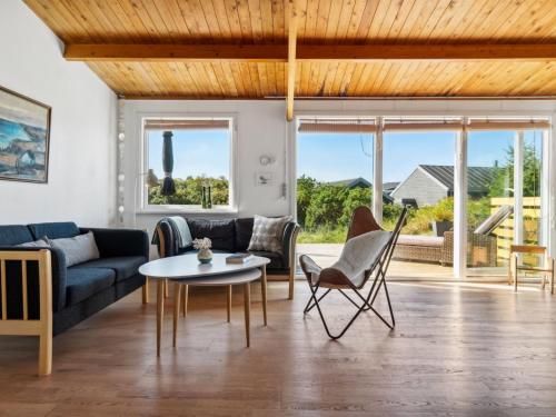 ein Wohnzimmer mit einem Sofa, einem Tisch und Stühlen in der Unterkunft Holiday Home Satu - 500m from the sea in NW Jutland by Interhome in Torsted
