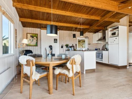 uma cozinha com uma mesa de madeira e cadeiras em Holiday Home Satu - 500m from the sea in NW Jutland by Interhome em Torsted