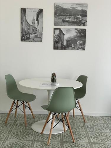 een tafel en twee stoelen en een witte tafel en stoelen bij Green House Calolziocorte in Calolziocorte