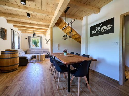 - une salle à manger et un salon avec une table et des chaises en bois dans l'établissement Holiday Home Muhu by Interhome, à Smržovka