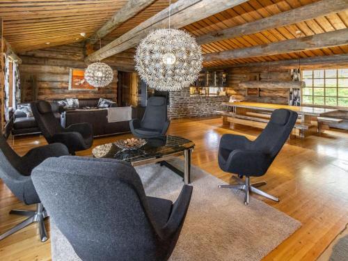 een woonkamer met zwarte stoelen en een kroonluchter bij Holiday Home Villihanhi by Interhome in Kuusamo