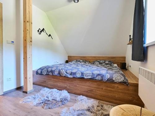 a bedroom with a bed and two rugs on the floor at Holiday Home Muhu by Interhome in Smržovka