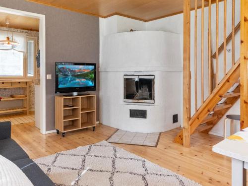 a living room with a tv and a fireplace at Holiday Home Villa vuorso by Interhome in Raanujärvi