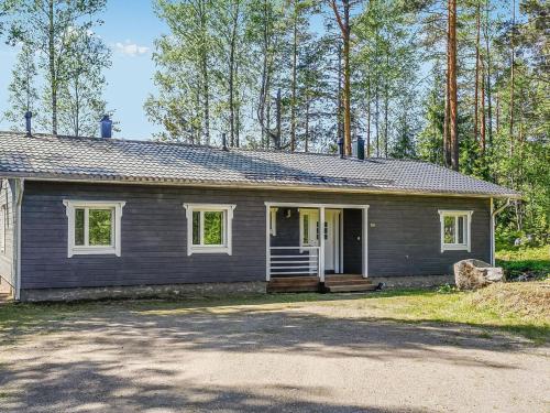 a gray house with a porch and a driveway at Holiday Home Aurinkokaari by Interhome in Heinävesi