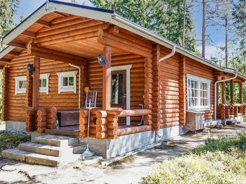 Cabaña de madera con escaleras que conducen a la puerta principal en Holiday Home Itälahti by Interhome, en Ihamaniemi