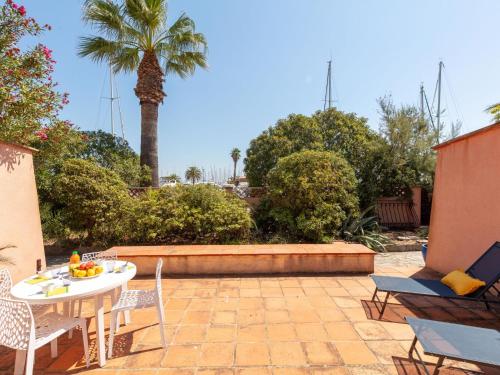 a patio with a table and chairs and a palm tree at Villa Cantegril by Interhome in Hyères