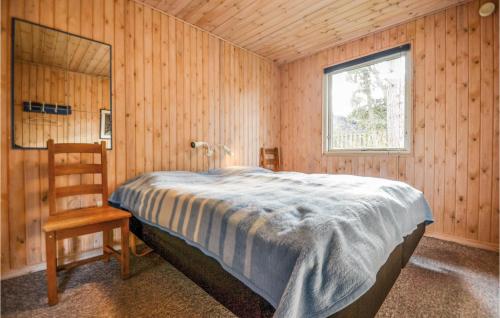 エーベルトフトにあるAwesome Home In Ebeltoft With 5 Bedrooms And Saunaのベッドルーム1室(ベッド1台、椅子、窓付)