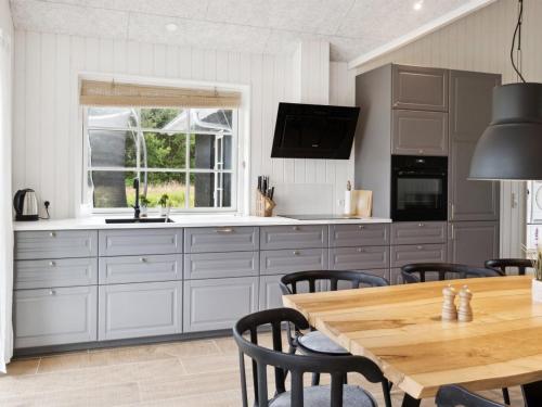 eine Küche mit Holztisch und ein Esszimmer in der Unterkunft Holiday Home Bryngeir - 750m from the sea by Interhome in Brøndstrup