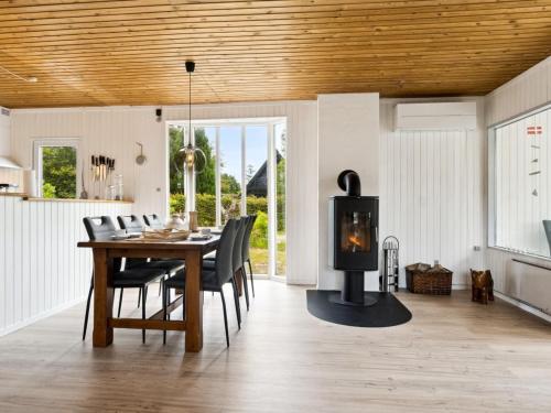 a kitchen and dining room with a wood burning stove at Holiday Home Neea - 280m from the sea by Interhome in Hadsund